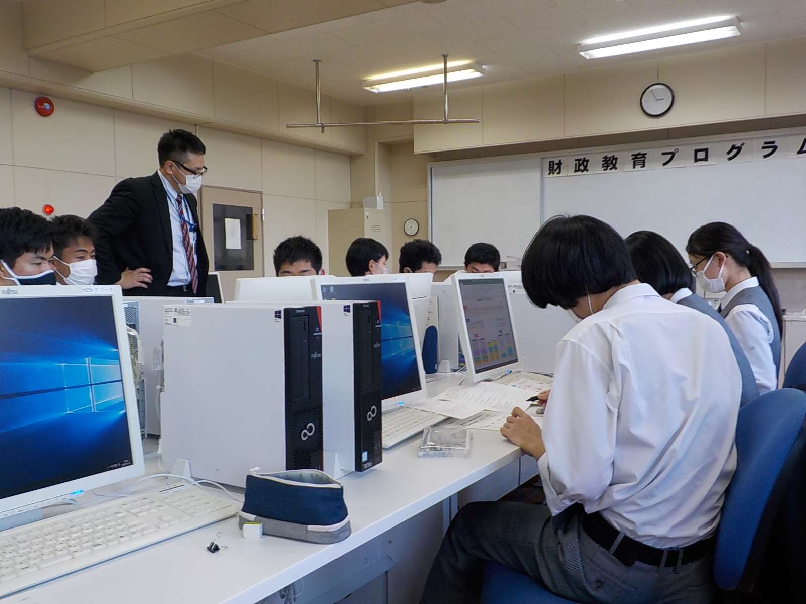 グループワークで予算案を作成する生徒を見守る講師